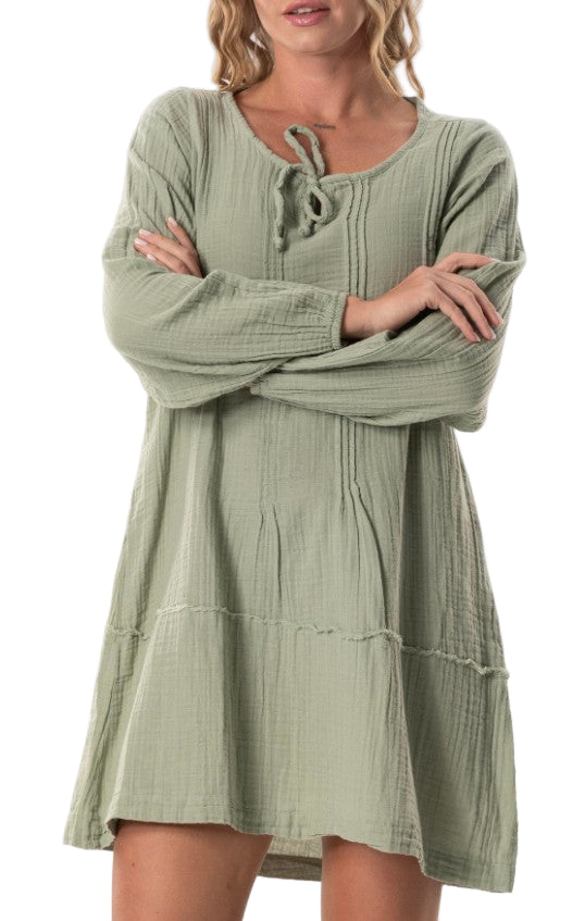 Woman wearing a green dress with long sleeves on a white background