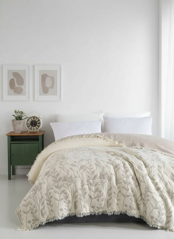 Bed with patterned beige comforter against a paneled wall
